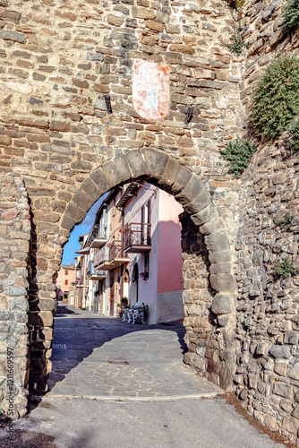 Obraz na płótnie The city gate of Collemancio reveals perfectly preserved medieval architecture against a clear blue sky in Umbria. The village of Collemancio is a national heritage site in Italy w salonie