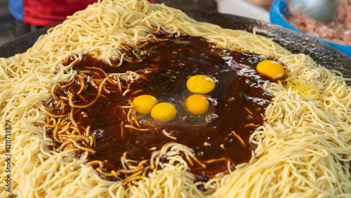 Eggs and Noodles Being Prepared in Rich Sauce for Cooking photo