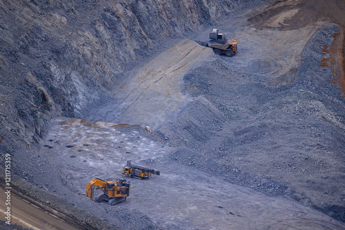 Heavy Machinery in Action at a Large Open-Pit Mining Site on Rocky Terrain photo