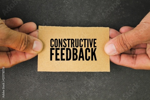 hand and paper with the word constructive feedback. the concept of consumer or customer response. a response to someone's activity aimed at helping them become more effective