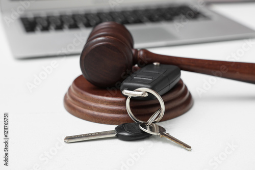 Auction gavel with car key on white background, closeup