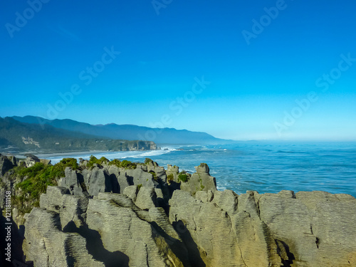 Layered limestone formations Pancake Rocks and Blowholes rise from sea in Punakaiki, South Island New Zealand. Unique landscape in Paparoa National Park. Explore rugged beauty of wild West Coast photo