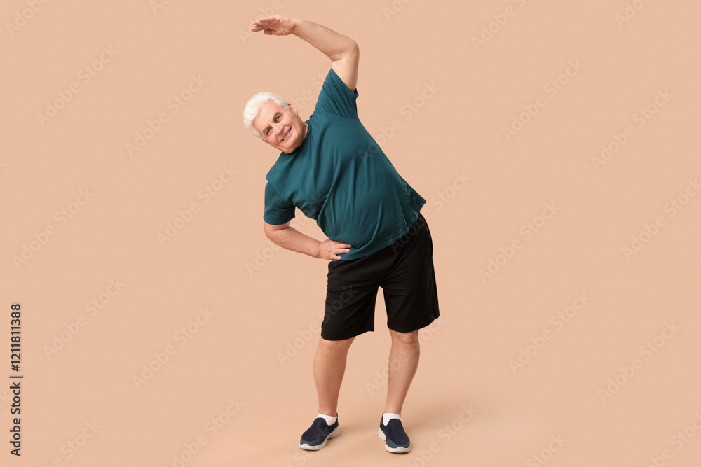 Fototapeta premium Sporty senior man exercising on beige background