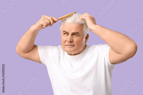 Senior man brushing hair on...