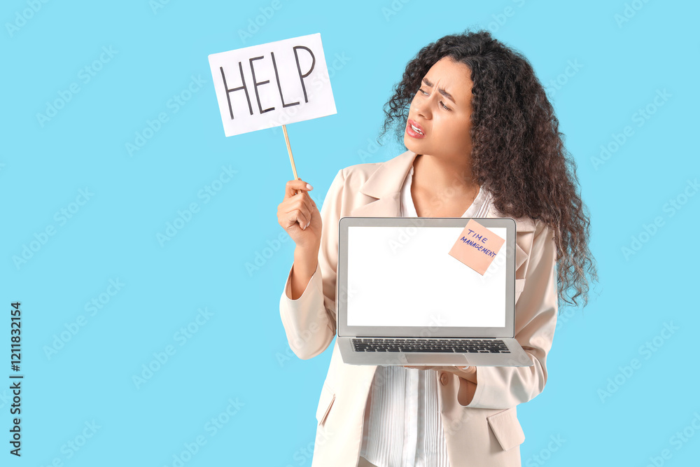Young African-American businesswoman holding sign with word HELP and laptop on blue background. Time management concept Young African-American businesswoman holding sign with word HELP and laptop on blue background. Time management concept