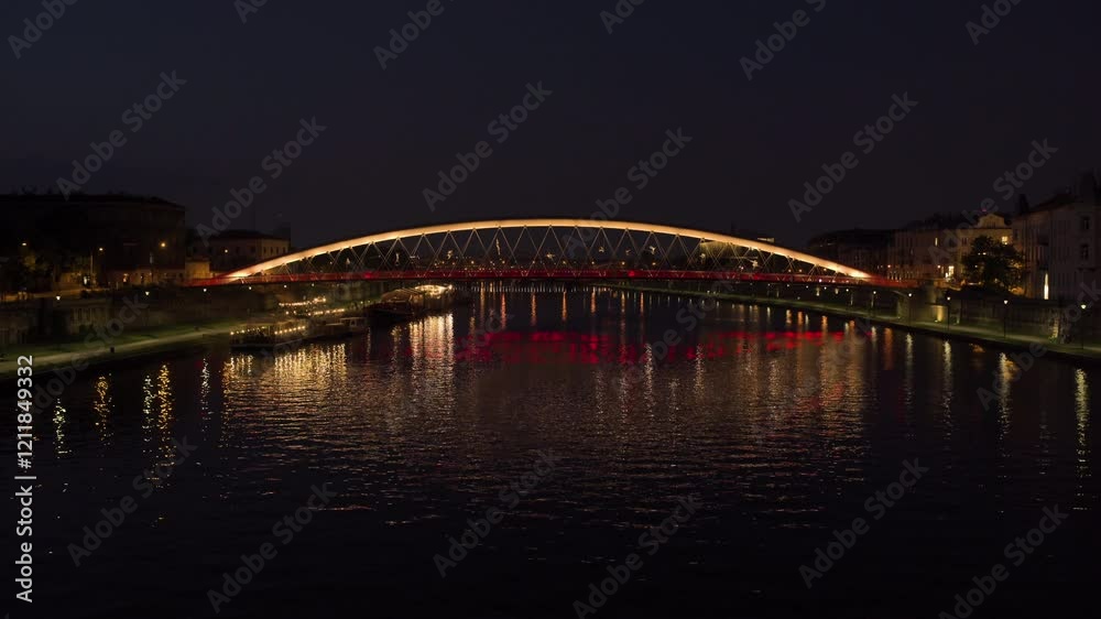 Beautiful illuminated bridge over calm river at night in vibrant city landscape Beautiful illuminated bridge over calm river at night in vibrant city landscape