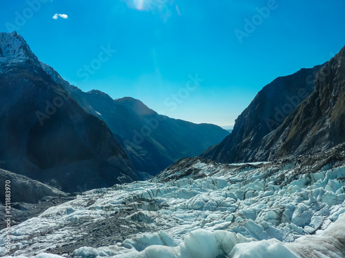 Icy expanse of Franz Josef Glacier, Westland Tai Poutini National Park, South Island, New Zealand. Jagged ice formations, deep crevasses, towering snow-capped peaks create dramatic alpine landscape photo