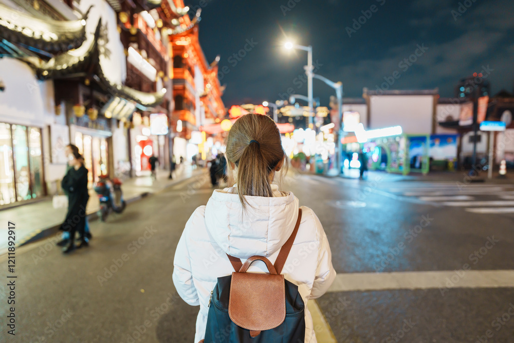 woman traveler visiting in Shanghai, China. Happy Female Tourist sightseeing and shopping in Yuyuan Old Street market at night. landmark and popular for tourism attractions. Travel and Vacation