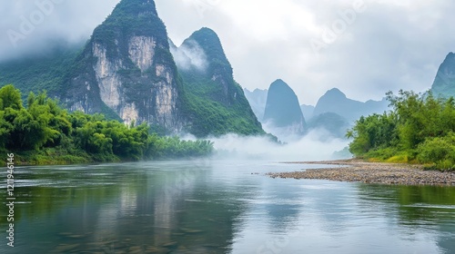 Serene river landscape with majestic mountains and fog on a cloudy day reflecting in tranquil waterçŽ¯å¢ƒä¸Žå£®ä¸½å±±è„‰çš„æ²³æµæ™¯è§‚ photo