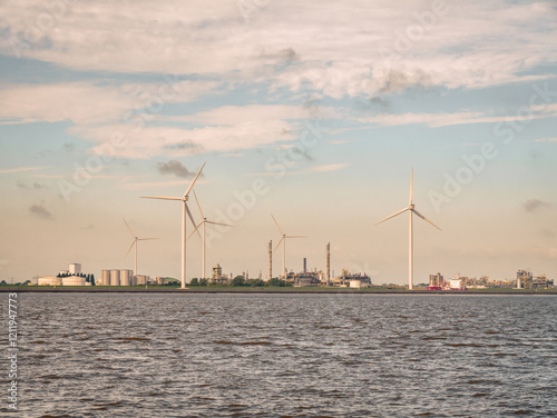 Industrial landscape: windfarm and factories at Chemiepark Delfzijl, Groningen, along Eems estuary, Netherlands photo