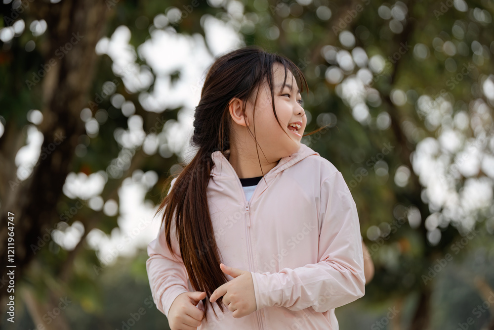 Joyful daughter exercising outdoors, smiling during her active playtime surrounded by nature Joyful daughter exercising outdoors, smiling during her active playtime surrounded by nature