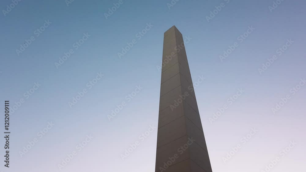 The Buenos Aires Obelisk at sunset on 9 de Julio Avenue, iconic landmark and urban symbol, establishing tilt up against blue sky The Buenos Aires Obelisk at sunset on 9 de Julio Avenue, iconic landmark and urban symbol, establishing tilt up against blue sky