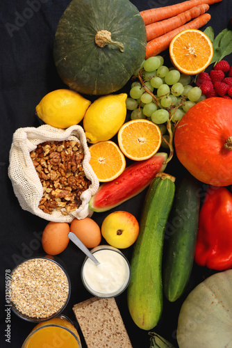 Various healthy fruits, vegetables and cereals on dark background. Top view.