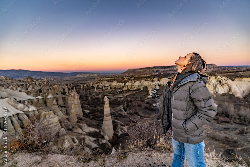 Pensive woman looking up at the sky, feeling melancholy above Love Valley in Cappadocia