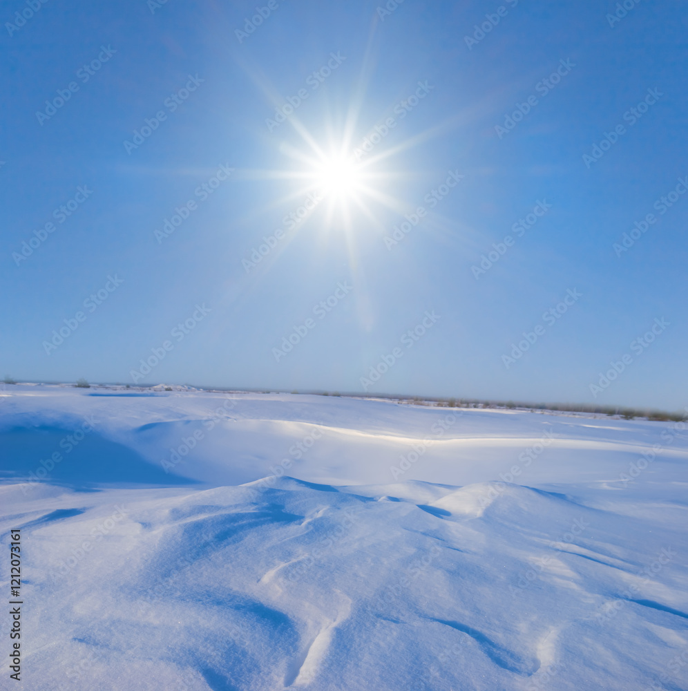 wide snowbound plain at the sunny winter day