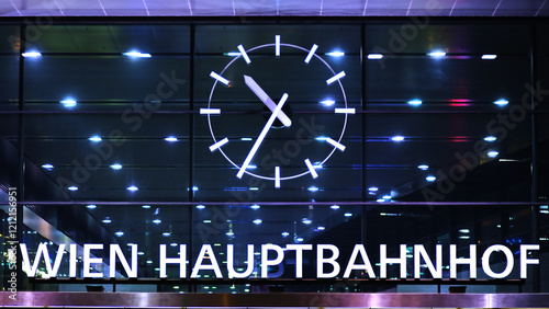 A night scene of the entrance of Wien Hauptbahnhof, prominently featuring a bright clock, reflecting urban sophistication and the importance of punctuality. photo