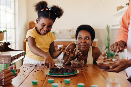 Happy Brazilian family making traditional brigadeiro dessert together photo