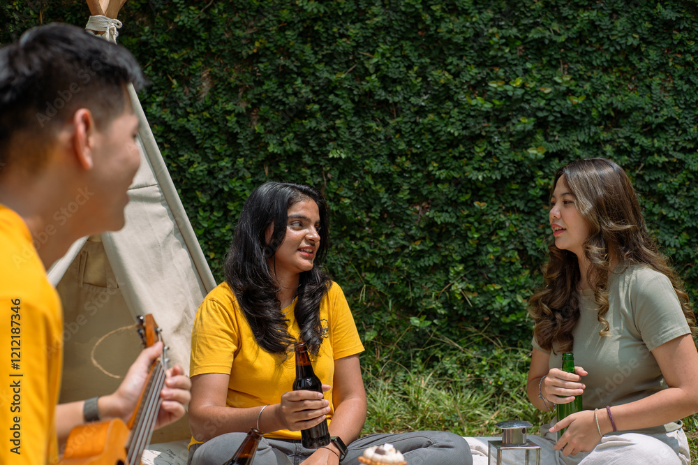 A group of Asian friends enjoying a casual outdoor picnic, holding drinks and engaged in a lively conversation. They sit near a tipi in a lush garden setting, creating a warm and relaxed atmosphere A group of Asian friends enjoying a casual outdoor picnic, holding drinks and engaged in a lively conversation. They sit near a tipi in a lush garden setting, creating a warm and relaxed atmosphere