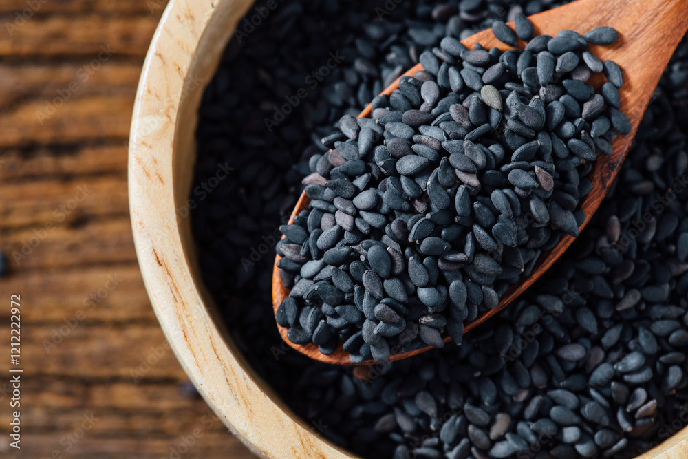 Black sesame in bowl on wooden background Black sesame in bowl on wooden background