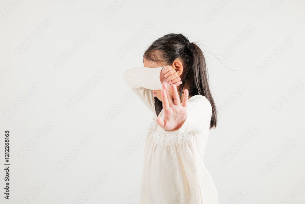 Asian portrait cute young kid girl smiling doing show stop sign gesture with palm of hand but unhappy face studio shot isolated on white background, kindergarten children doubt with copy space Asian portrait cute young kid girl smiling doing show stop sign gesture with palm of hand but unhappy face studio shot isolated on white background, kindergarten children doubt with copy space