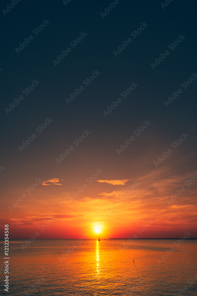 Fototapeta premium Serene Sunset Over the Open Ocean with Calm Reflecting Waters.