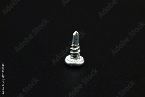 Short self-tapping screw for metal on a black background