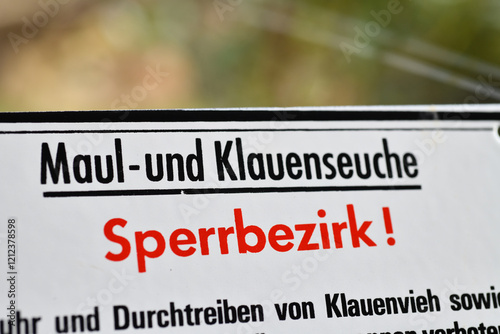 Burgdorf, Germany - January 22, 2025: Warning sign with the text Foot and mouth disease - restricted area - in German: Maul und Klauenseuche photo