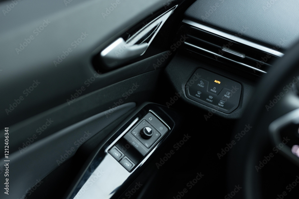 Window control buttons in modern luxury electric car. Car leather interior details of door handle with windows controls and adjustments. Car window controls. Door handle with power window control Window control buttons in modern luxury electric car. Car leather interior details of door handle with windows controls and adjustments. Car window controls. Door handle with power window control