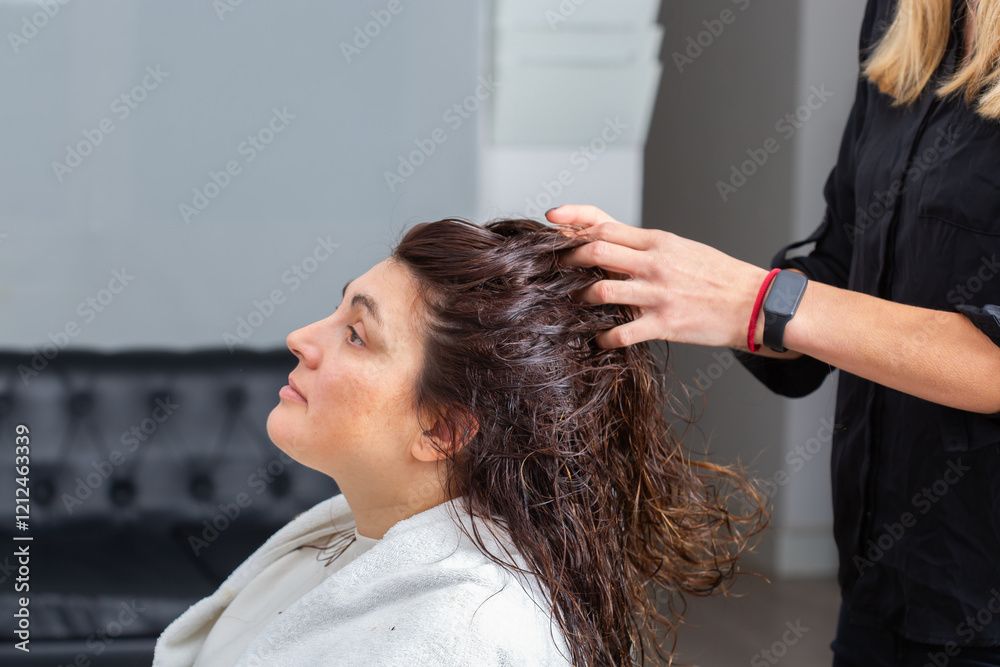 Fototapeta premium Hairstylist massages head and scalp for a young female client