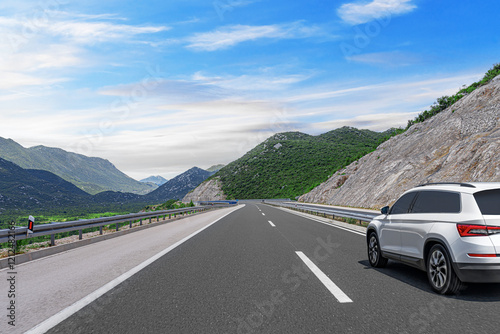 Obraz na płótnie The car is driving along the highway surrounded by picturesque nature. w salonie