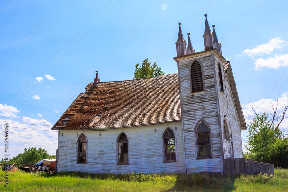 A small, old church with a steeple and a cross on top A small, old church with a steeple and a cross on top
