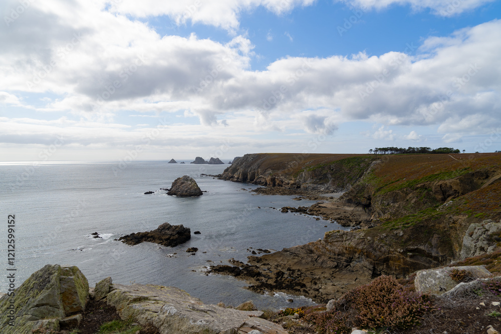 La mer d’Iroise, d’un bleu profond, longe les falaises imposantes de la côte sauvage de Crozon, sous un ciel bleu parsemé de nuages blancs. La mer d’Iroise, d’un bleu profond, longe les falaises imposantes de la côte sauvage de Crozon, sous un ciel bleu parsemé de nuages blancs.