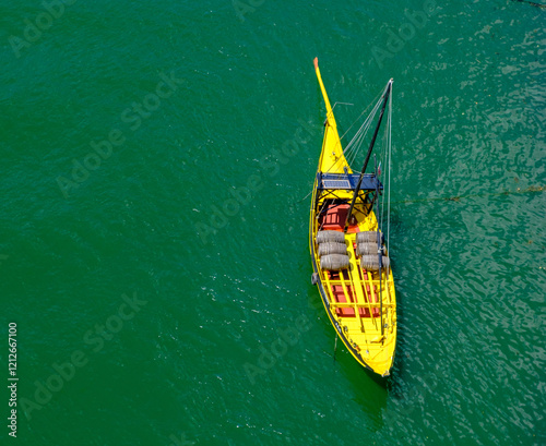 yellow boat against the  green sea photo