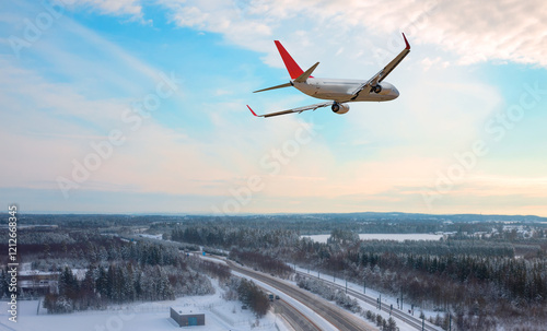 Passenger plane fly up over take-off runway from airport  at Oslo Gardermoen International Airport - Airport in a snow covered - Beautiful winter landscape with aerial view of highway road - Norway photo