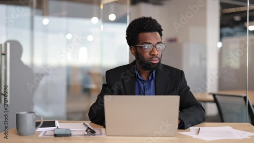 Wallpaper Mural Focused businessman working on laptop in modern office. Thoughtful male professional analyzing data, developing strategy, solving problem. Torontodigital.ca