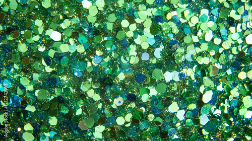 Close-up of vibrant green glitter with hexagonal sequins creating a sparkling and dynamic texture. Ideal for festive and creative projects photo