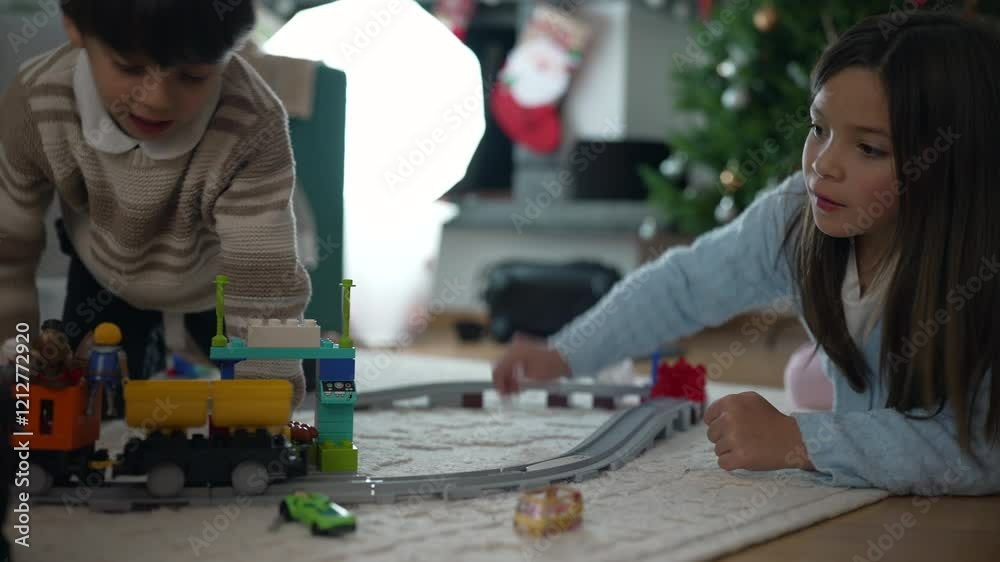 Engaged Siblings Playing with Toy Train Set on Living Room Floor, Imaginative Playtime with Railway Tracks and Trains, Symbolizing Childhood and Creativity