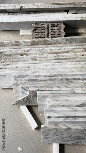 A pile of marble slabs and building materials on the floor in a newly constructed apartment. The image reflects ongoing construction and renovation efforts, showing the transition to a finished home. photo