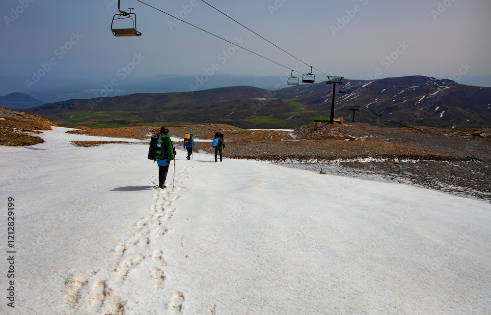 Hiking through the snowy terrain as winter wanes on a remote mountain trail. Copy space.