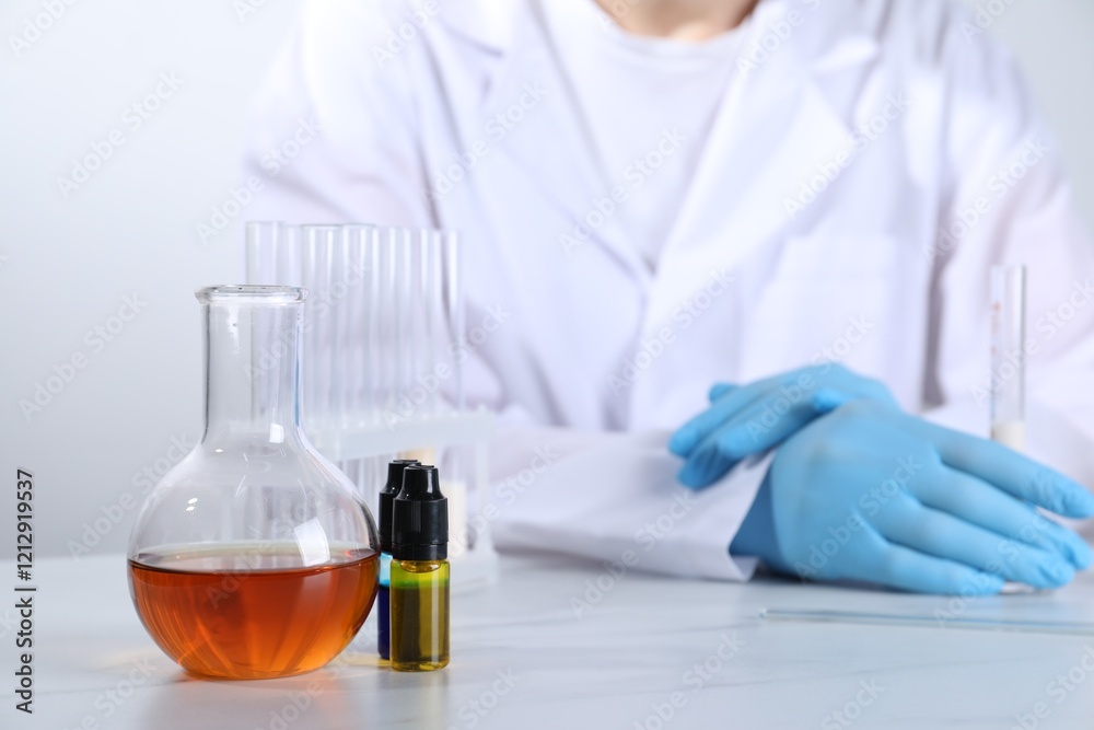 Laboratory testing. Scientist working at white marble table, focus on glassware Laboratory testing. Scientist working at white marble table, focus on glassware