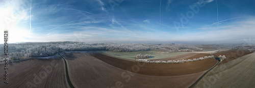 Winter landscape in Germany with frozen frost on trees and fields, drone shot photo