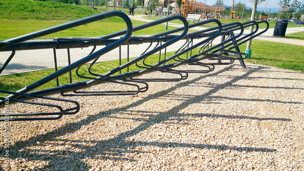 A row of bicycle racks are neatly lined up in a park, providing a convenient place for cyclists to securely park their bicycles while enjoying the outdoor scenery A row of bicycle racks are neatly lined up in a park, providing a convenient place for cyclists to securely park their bicycles while enjoying the outdoor scenery
