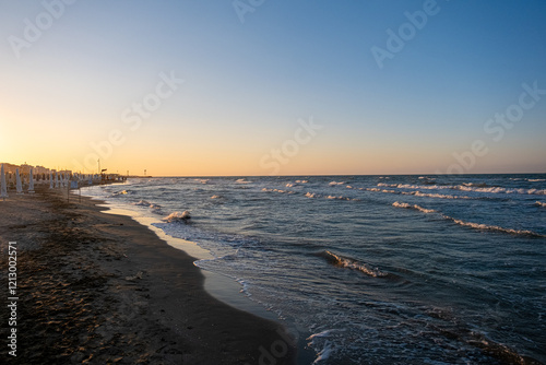 dawn on the beach of Cesenatico with sun and gentle waves. High quality photo