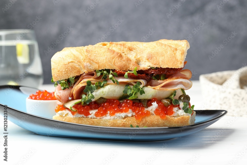 Delicious baguette sandwich with caviar, ham and capers on white wooden table, closeup Delicious baguette sandwich with caviar, ham and capers on white wooden table, closeup