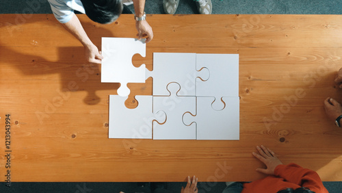 Fotografie Top down view of skilled business people assemble jigsaw puzzle on meeting table