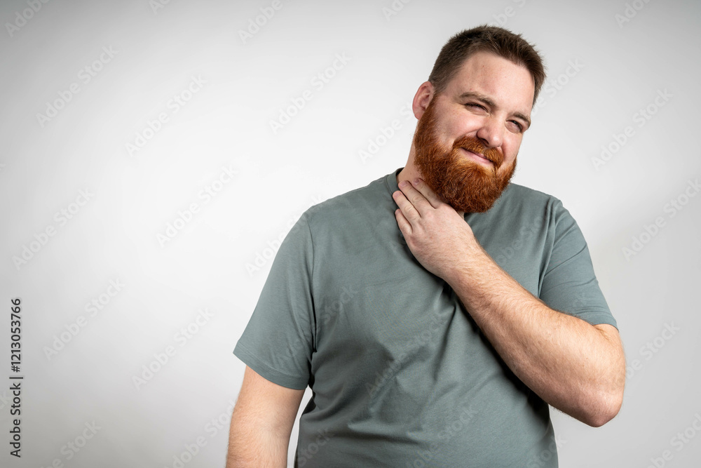Obraz premium young bearded man feeling ill with a sore throat and flu symptoms, coughing with mouth covered against grey wall