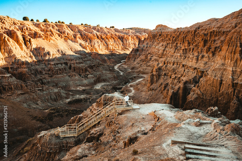 Woman is hiking down a staircase into a canyon at Cathedral Gorge State Park, Panaca, Lincoln County, Nevada, USA photo