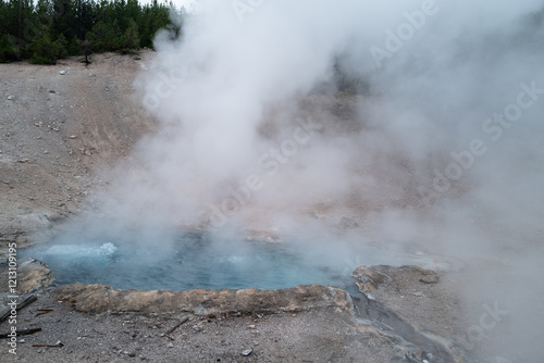 Beautiful deep blue colors and sedimentary rim of the various hot springs within Yellowstone National park photo