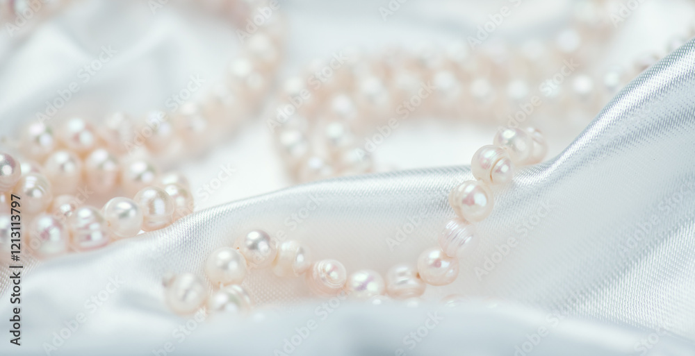 Pearl necklace over white silk background, close up. Beautiful Natural pearls beads, elegant accessories. Wedding concept, Valentine's Day Gift Pearl necklace over white silk background, close up. Beautiful Natural pearls beads, elegant accessories. Wedding concept, Valentine's Day Gift