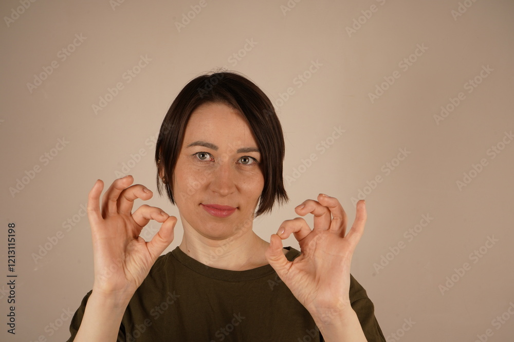 Picture of lovely woman creating a frame with fingers isolated on gray background. Picture of lovely woman creating a frame with fingers isolated on gray background.